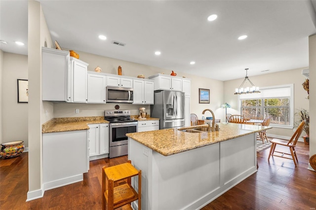 kitchen with dark wood finished floors, white cabinets, visible vents, and appliances with stainless steel finishes