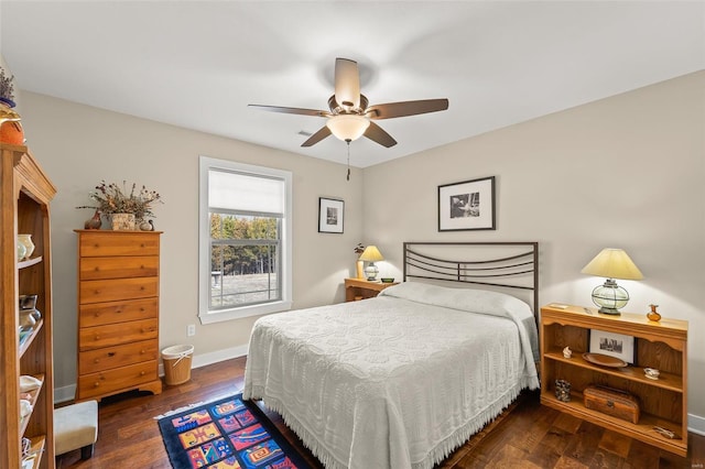 bedroom with hardwood / wood-style flooring, a ceiling fan, and baseboards