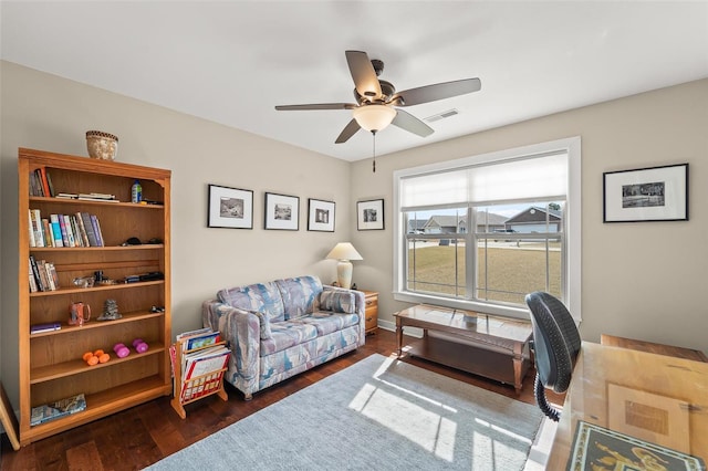 home office with ceiling fan, visible vents, and wood finished floors