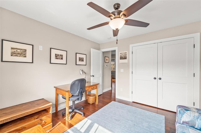 office area featuring baseboards, dark wood-type flooring, and a ceiling fan