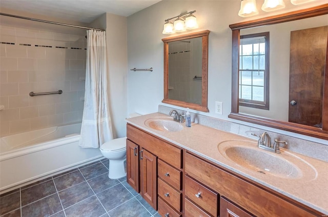 full bathroom with double vanity, tile patterned flooring, a sink, and toilet