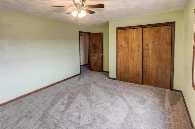 unfurnished bedroom featuring a ceiling fan, carpet, a closet, and baseboards