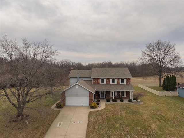 view of front of home with an attached garage, brick siding, fence, driveway, and a front yard