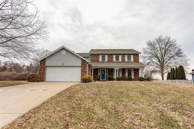 traditional-style home featuring a garage, brick siding, fence, concrete driveway, and a front yard