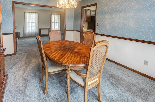 dining area featuring baseboards, carpet floors, a notable chandelier, and wallpapered walls