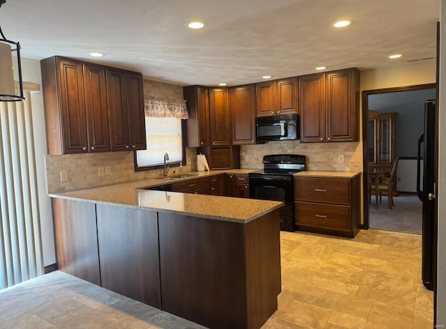 kitchen featuring tasteful backsplash, a peninsula, light countertops, black appliances, and a sink