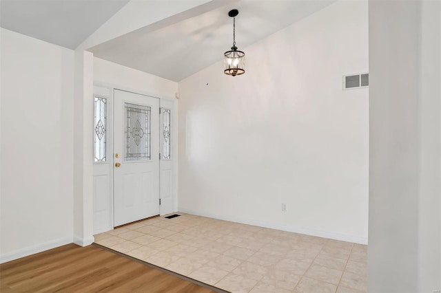 foyer entrance with visible vents, baseboards, light wood-type flooring, and lofted ceiling