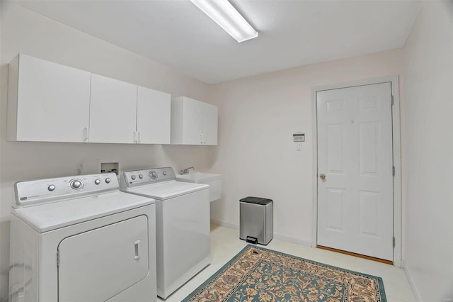 laundry area featuring baseboards, cabinet space, independent washer and dryer, and a sink