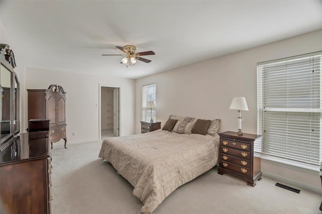 bedroom with visible vents, light carpet, baseboards, and a ceiling fan