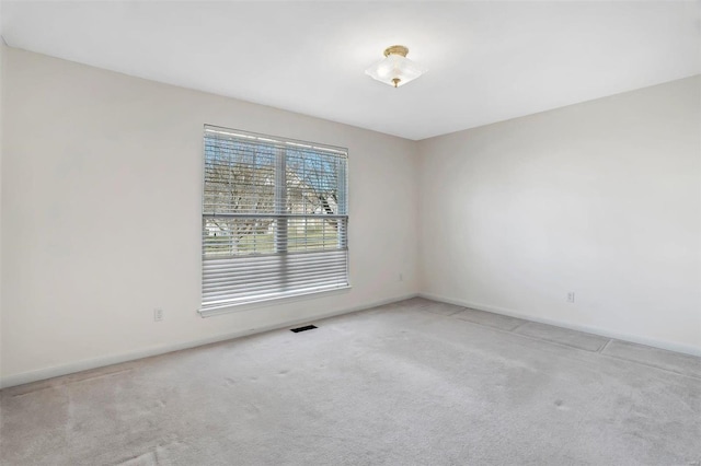 unfurnished room featuring visible vents, carpet floors, and baseboards