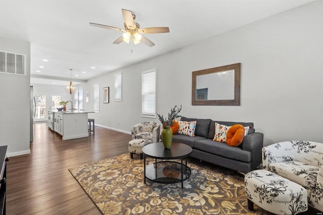 living room featuring recessed lighting, visible vents, dark wood-type flooring, baseboards, and ceiling fan with notable chandelier