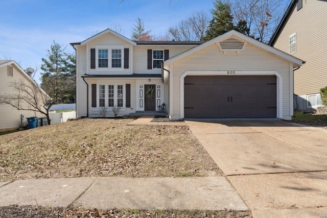 traditional-style house featuring concrete driveway and an attached garage