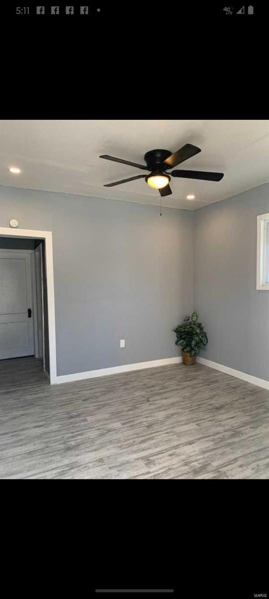 empty room with ceiling fan, baseboards, and wood finished floors