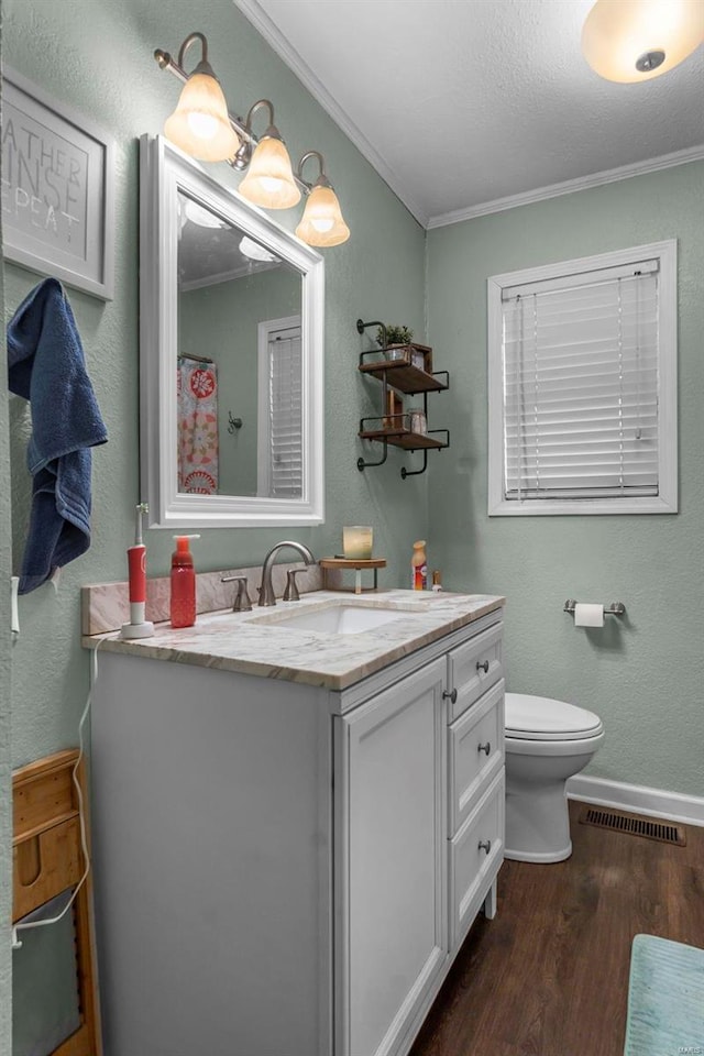 full bath featuring vanity, ornamental molding, wood finished floors, and visible vents