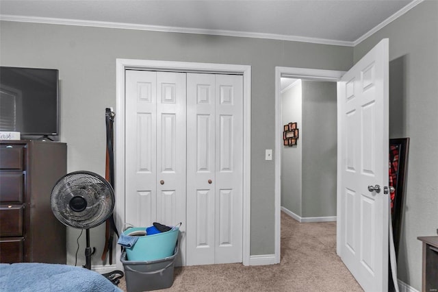 bedroom with carpet, crown molding, baseboards, and a closet