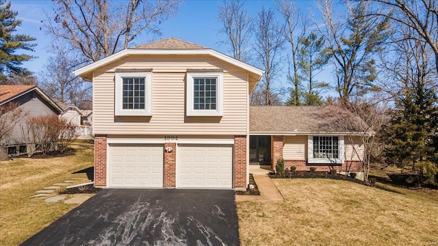 view of front of home with an attached garage, brick siding, a front yard, and aphalt driveway