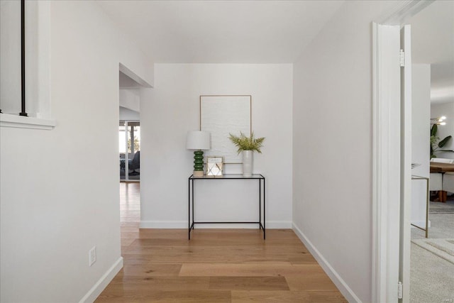 hallway featuring light wood-style floors and baseboards