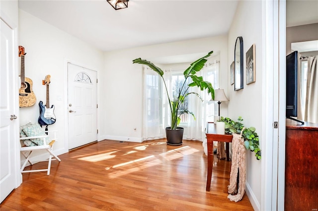 entrance foyer featuring baseboards and light wood finished floors