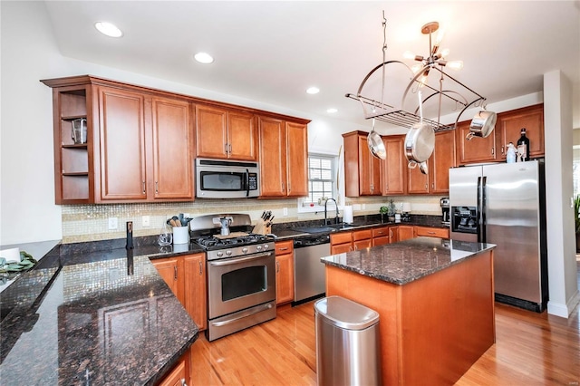 kitchen featuring brown cabinets, light wood finished floors, open shelves, stainless steel appliances, and decorative backsplash