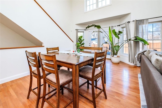 dining space featuring baseboards, a wealth of natural light, and light wood-style floors