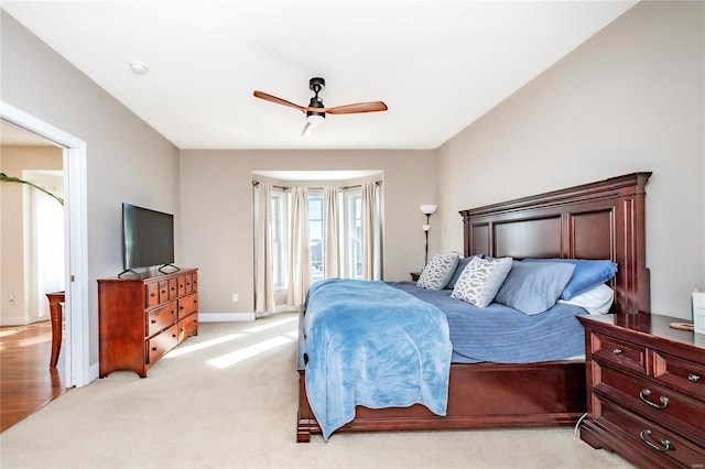 bedroom featuring light carpet, access to exterior, a ceiling fan, and baseboards