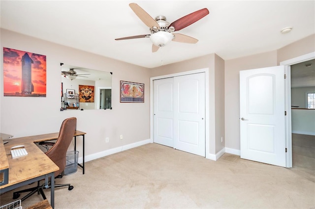 carpeted office with a ceiling fan and baseboards