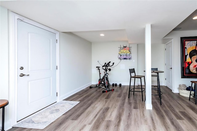 workout area with recessed lighting, baseboards, and wood finished floors