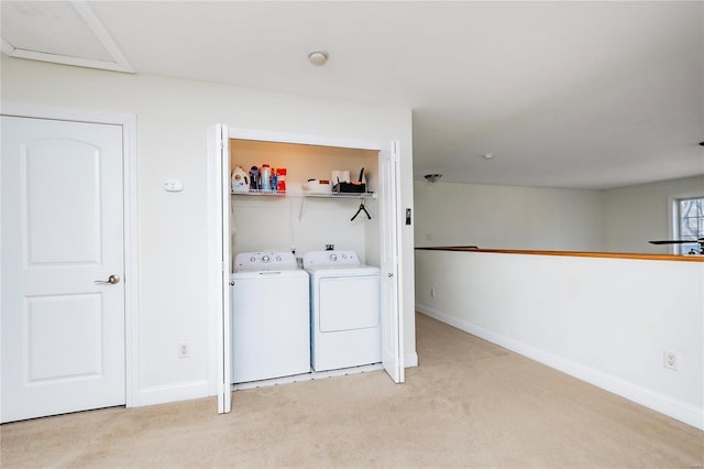 laundry room featuring baseboards, laundry area, washer and clothes dryer, and light colored carpet