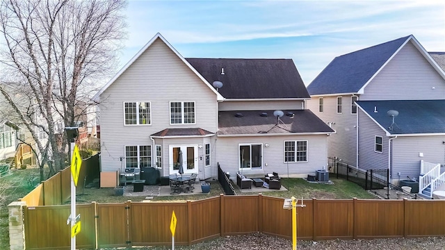 rear view of property with entry steps, a gate, a patio area, central AC, and a fenced backyard