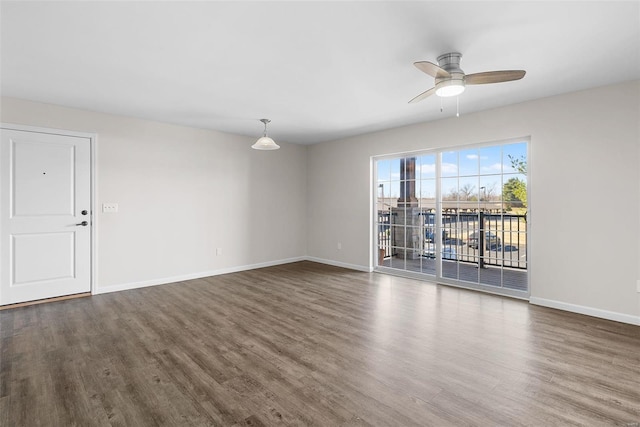 empty room with ceiling fan, baseboards, and wood finished floors