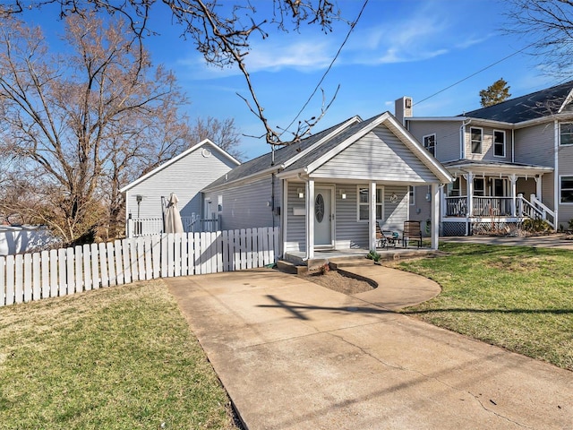 view of front facade featuring a fenced front yard, a chimney, a porch, and a front lawn