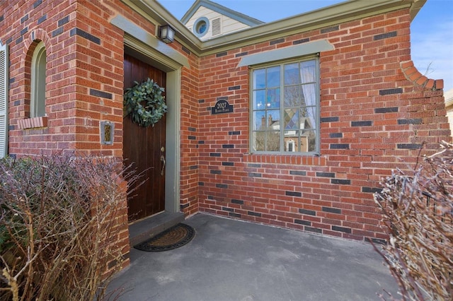 view of exterior entry with brick siding