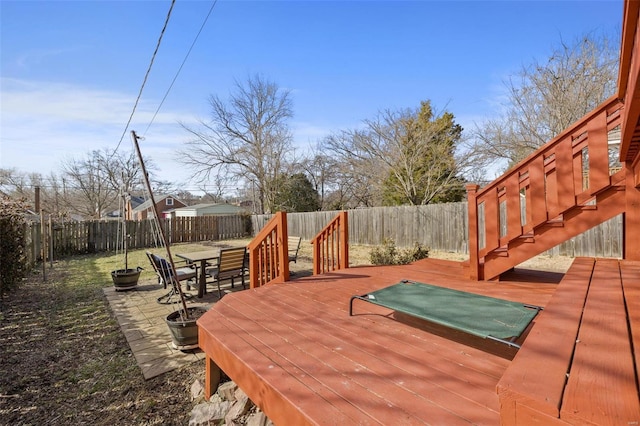 wooden terrace with outdoor dining space and a fenced backyard