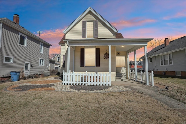 view of front of house featuring a porch, central AC, and fence