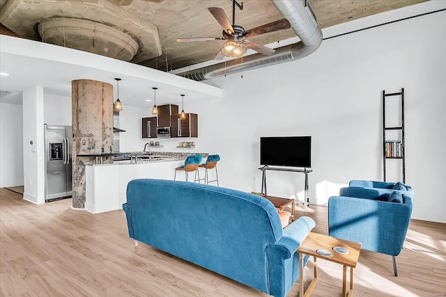 living room featuring ceiling fan and light wood-type flooring