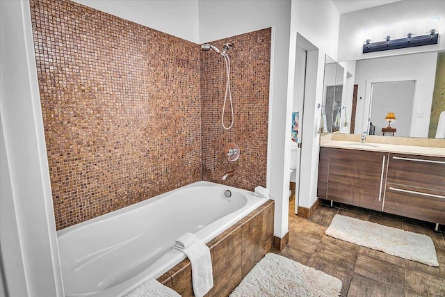 bathroom featuring toilet, tiled shower / bath combo, and vanity