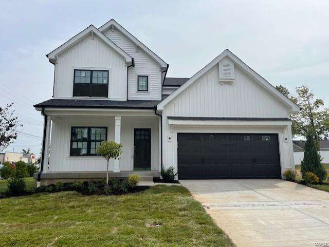 modern farmhouse featuring a porch, board and batten siding, a front yard, a garage, and driveway