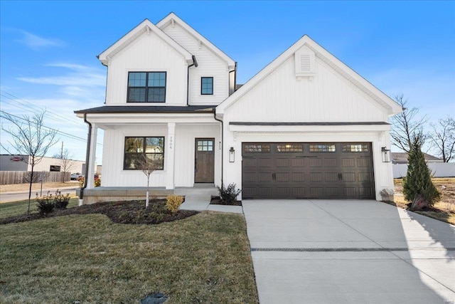 modern farmhouse style home with a porch, a garage, driveway, board and batten siding, and a front yard