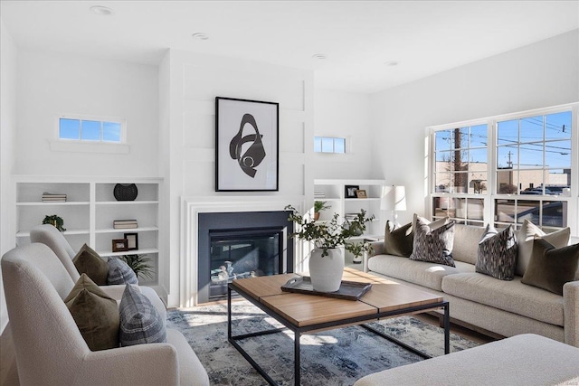 living room featuring a wealth of natural light and a glass covered fireplace