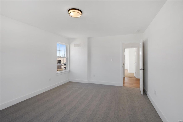 carpeted empty room with baseboards