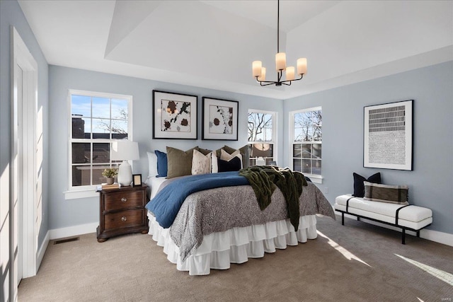 bedroom with a notable chandelier, light colored carpet, visible vents, baseboards, and a raised ceiling