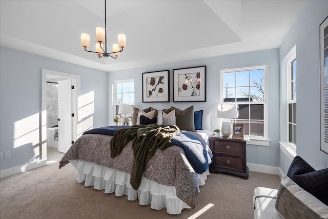 carpeted bedroom with an inviting chandelier, baseboards, and a raised ceiling