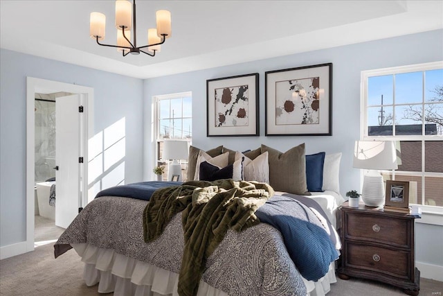 carpeted bedroom with baseboards, a tray ceiling, and a chandelier