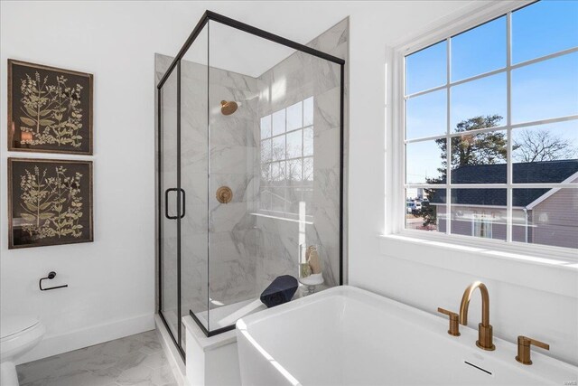 full bath featuring a freestanding bath, marble finish floor, and a shower stall