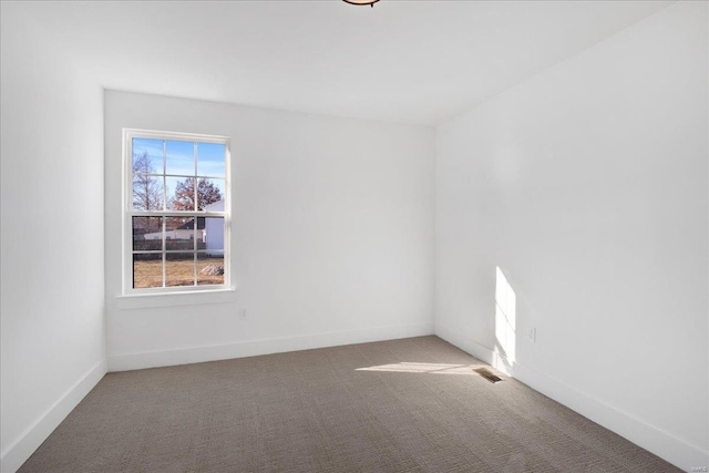 unfurnished room featuring carpet, visible vents, and baseboards