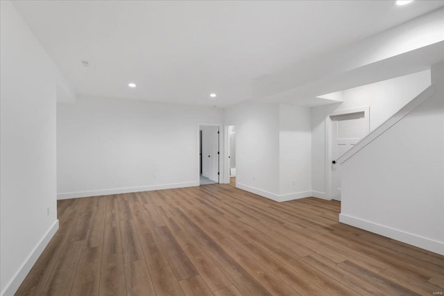 unfurnished room with recessed lighting, wood finished floors, and baseboards