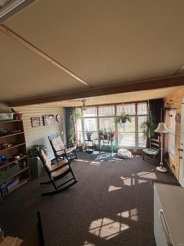 unfurnished living room featuring wood walls, carpet flooring, and a sunroom