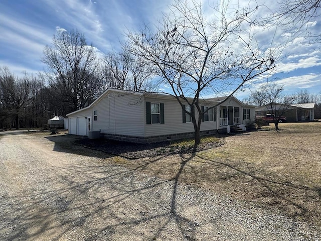 view of front of house featuring a garage, crawl space, dirt driveway, and central air condition unit