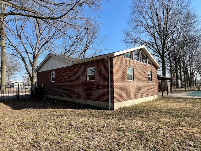 view of side of property with fence and brick siding