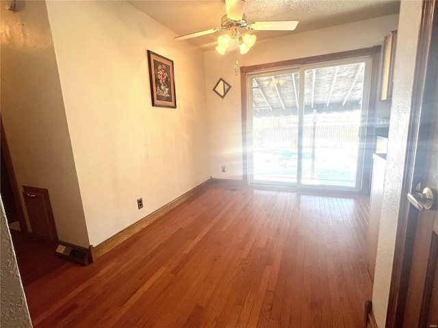 empty room featuring ceiling fan, hardwood / wood-style flooring, and baseboards